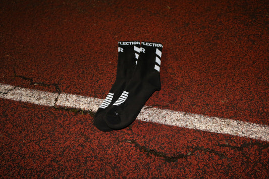 Reflective sport socks to be used by athletes for exercise and sports. These sportswear socks are cotton with reflective text and logos embodied into them for reflective purposes to aid visibility whilst performing exercise activities in the dark. At dusk, dawn or night. TRUE REFLECTION.